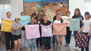 Apprentices showcasing their sewing projects.